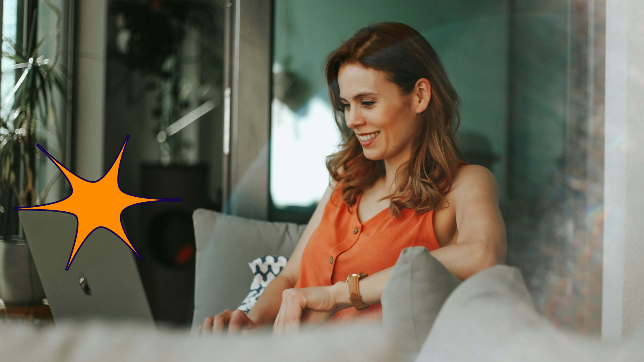 Woman sitting on couch, looking at laptop