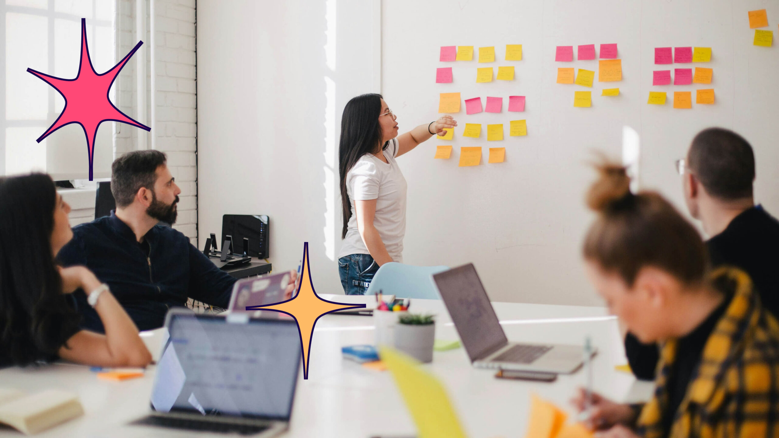 People standing around a white board and working