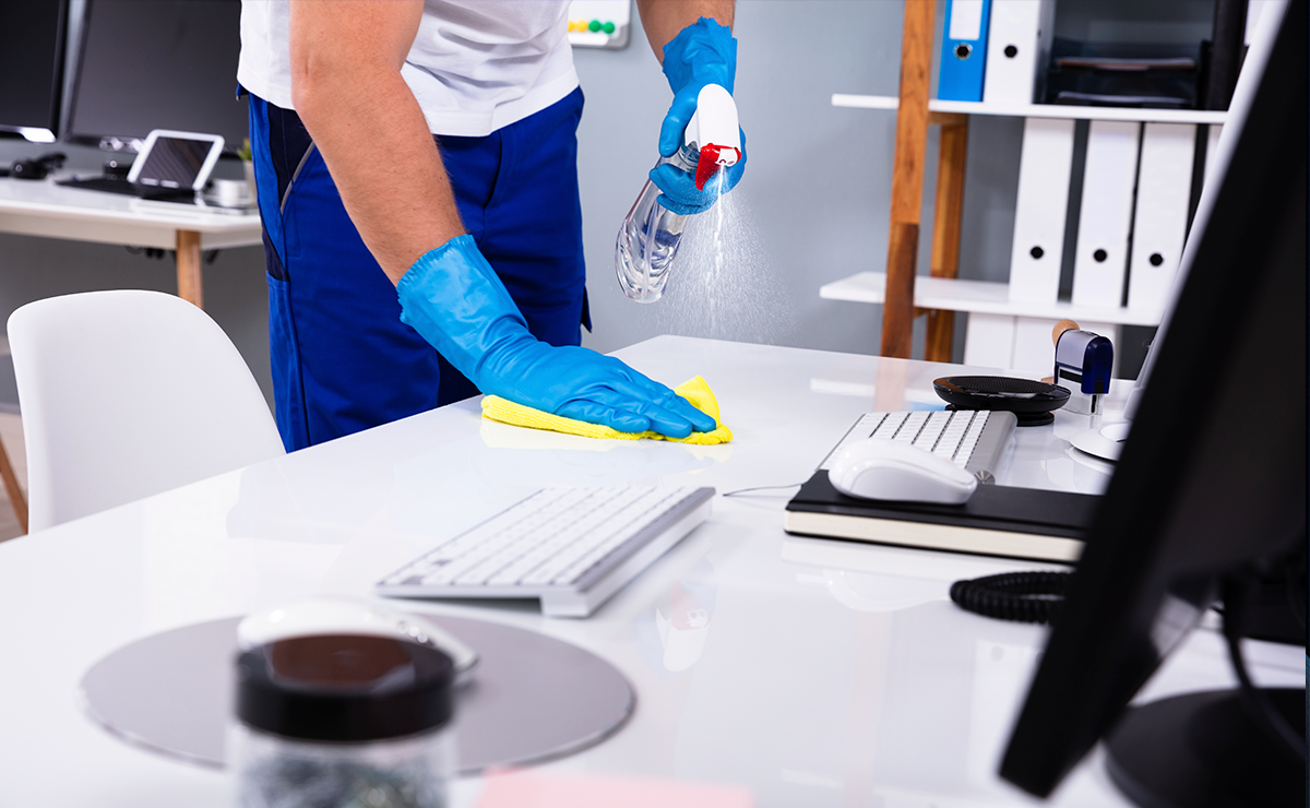 A person cleans an office desk.